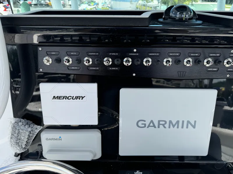 Slide: The Image of 2024 Wellcraft 262 Fisherman dashboard with Garmin and Mercury controls. - 12