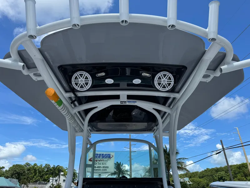 Slide: The Image of 2024 Wellcraft 262 Fisherman boat with T-top and speakers under a clear blue sky. - 14