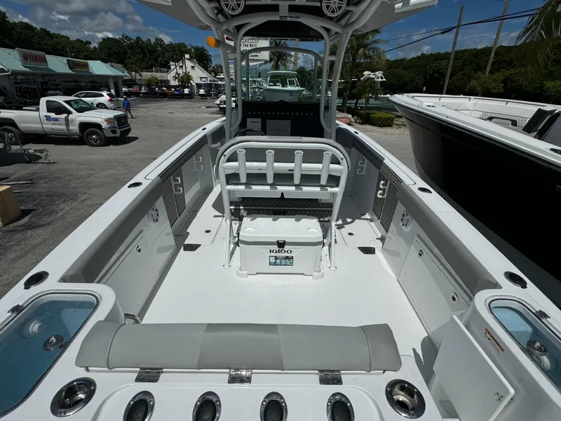 Slide: The Image of 2024 Wellcraft 262 Fisherman boat interior with seating and storage, parked outdoors. - 5
