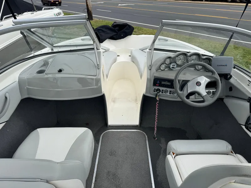 Slide: The Image of 2011 Bayliner 185 boat interior with steering wheel, dashboard, and seating. - 6