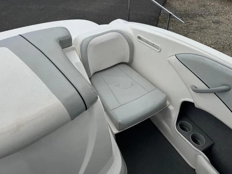 Slide: The Image of 2011 Bayliner 185 boat interior with gray and white seating and cup holders. - 7