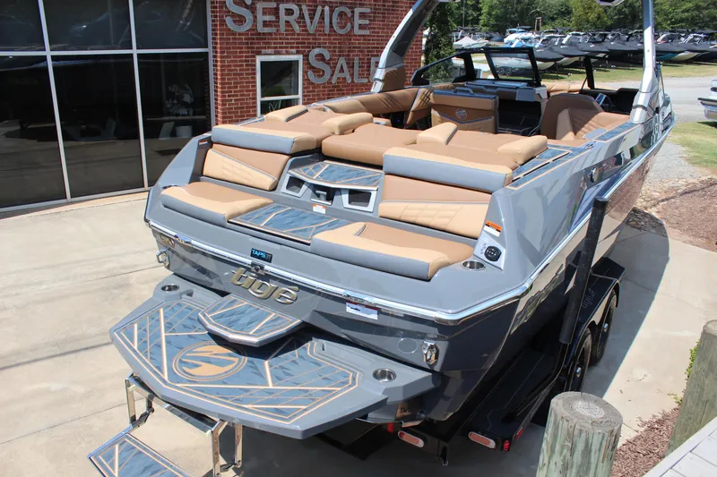 Slide: The Image of 2025 Tigé Ultré 23ZX boat with tan seating, displayed at a service and sales center. - 5