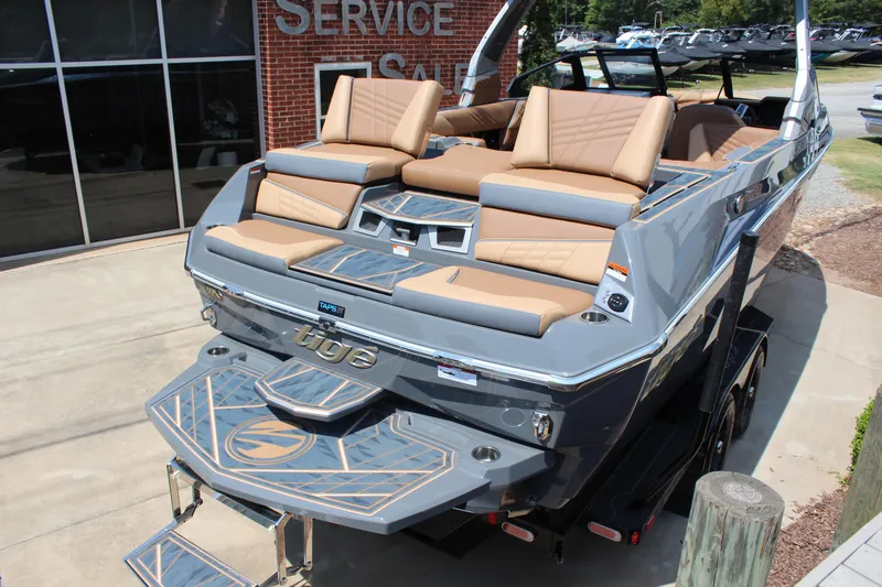 Slide: The Image of 2025 Tigé Ultré 23ZX boat with tan seating, displayed at a service center. - 6