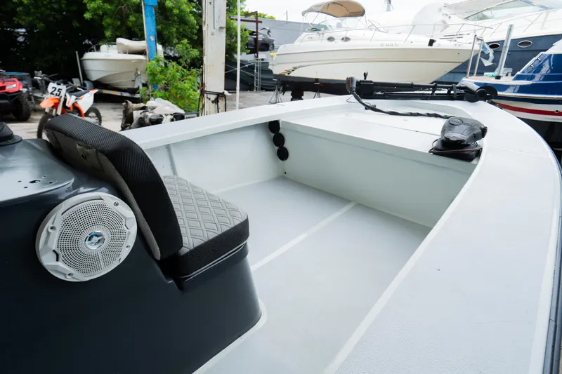 Slide: The Image of 1988 Baretta Success 185 boat interior with seating and speaker, docked near other boats. - 9