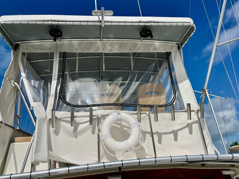 Slide: The Image of 1988 Jersey Dawn 40 boat with canopy and lifebuoy against blue sky. - 11