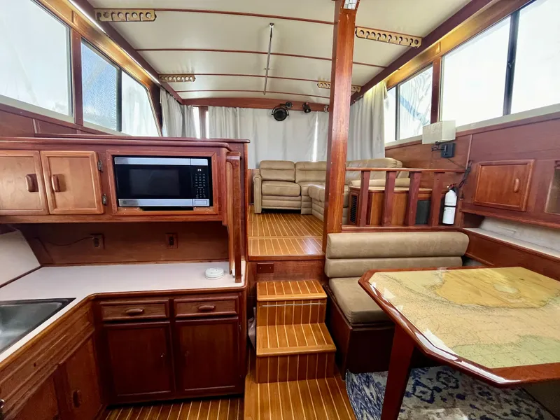 Slide: The Image of 1988 Jersey Dawn 40 yacht interior with wood finish, kitchenette, and seating area. - 26