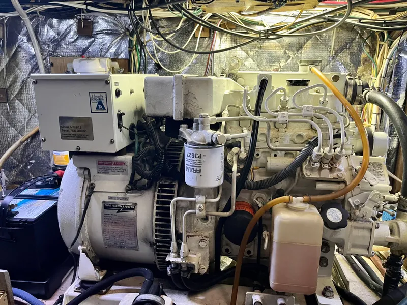 Slide: The Image of Engine room of a 1988 Jersey Dawn 40 boat, showcasing mechanical components and wiring. - 37