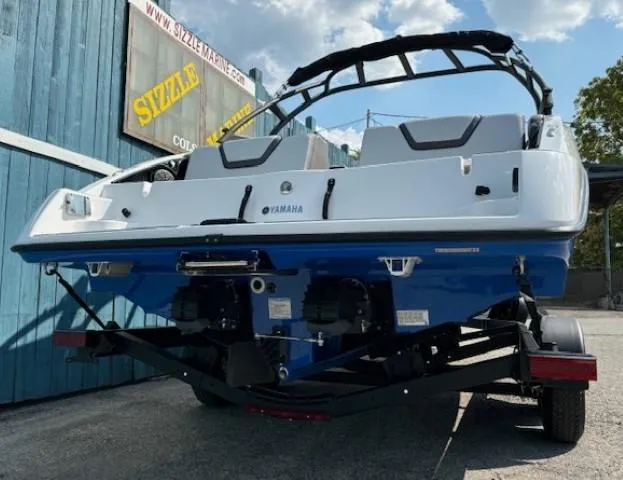 Slide: The Image of 2025 Yamaha AR250 boat on trailer, blue and white design, parked outdoors. - 3