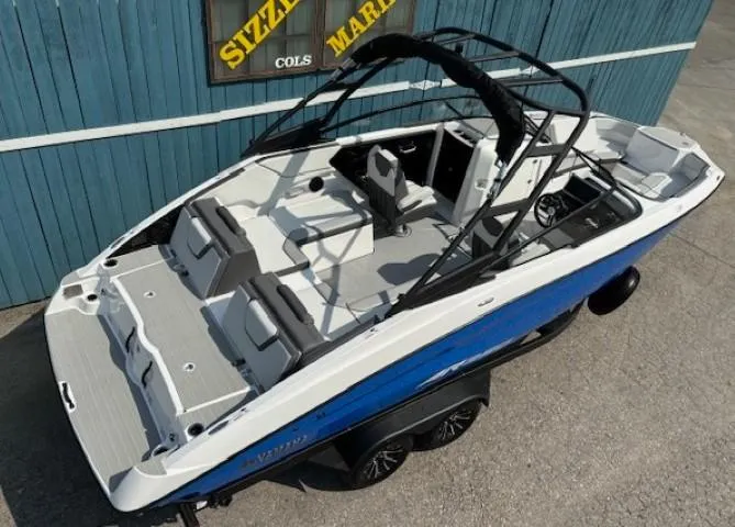 Slide: The Image of 2025 Yamaha Boats AR250, sleek design, blue and white, on trailer, outdoor display. - 5
