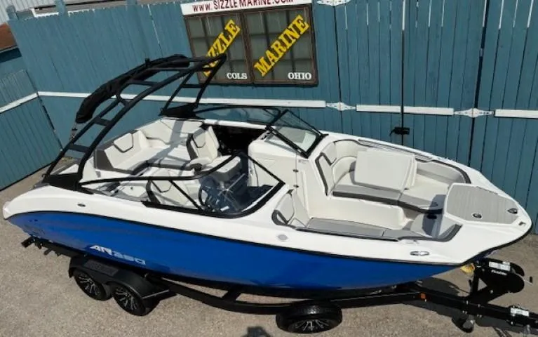 Slide: The Image of 2025 Yamaha Boats AR250, blue and white, on trailer, displayed outdoors. - 6