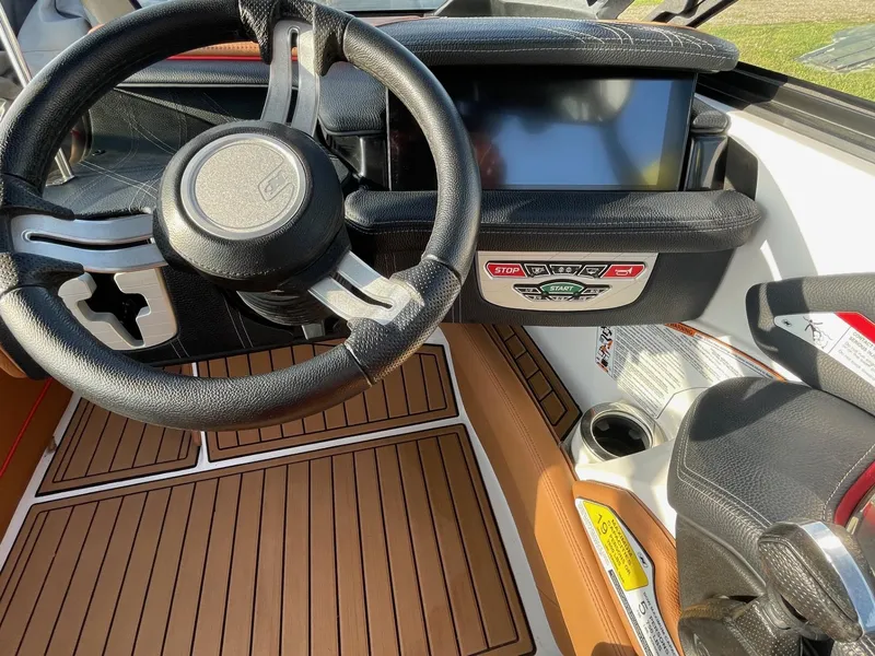 Slide: The Image of 2019 Nautique Super Air Nautique G25 dashboard with steering wheel and touchscreen display. - 12