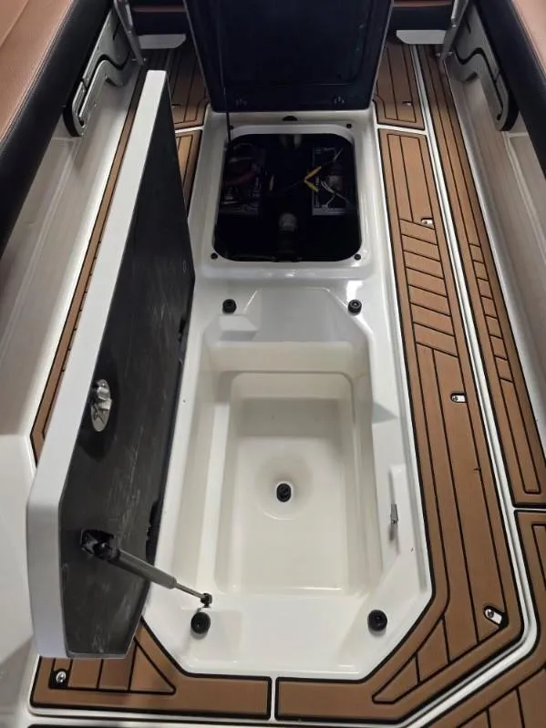Slide: The Image of 2019 Nautique Super Air Nautique G25 boat storage compartment with open hatch and teak flooring. - 17