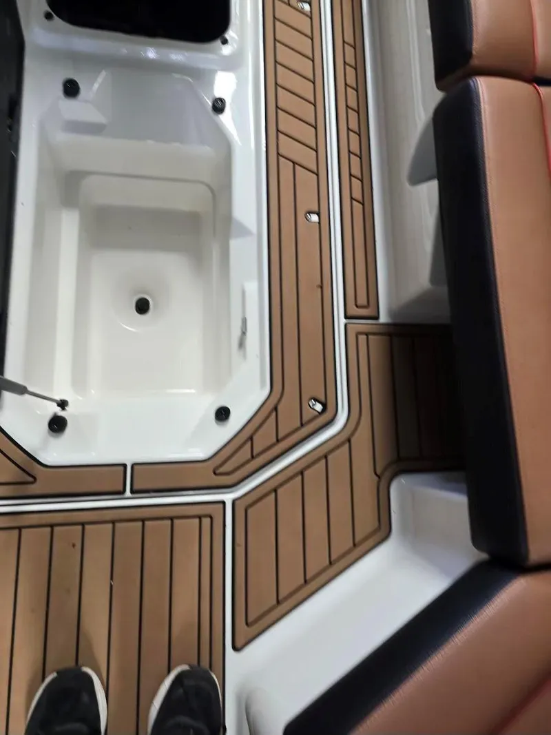 Slide: The Image of 2019 Nautique Super Air Nautique G25 interior with teak flooring and cushioned seating. - 18
