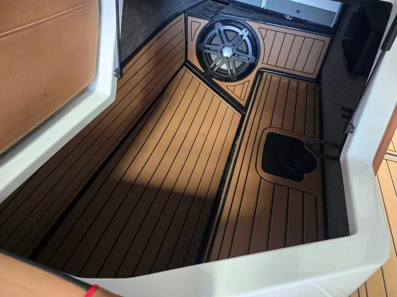 Slide: The Image of 2019 Nautique Super Air Nautique G25 interior with teak flooring and speaker system. - 20