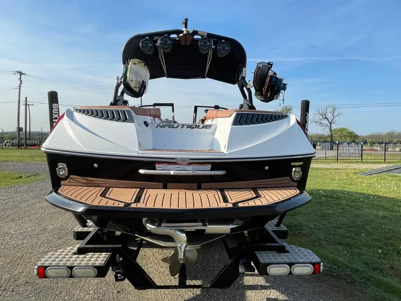Slide: The Image of 2019 Nautique Super Air Nautique G25 boat, rear view, parked on grass. - 3