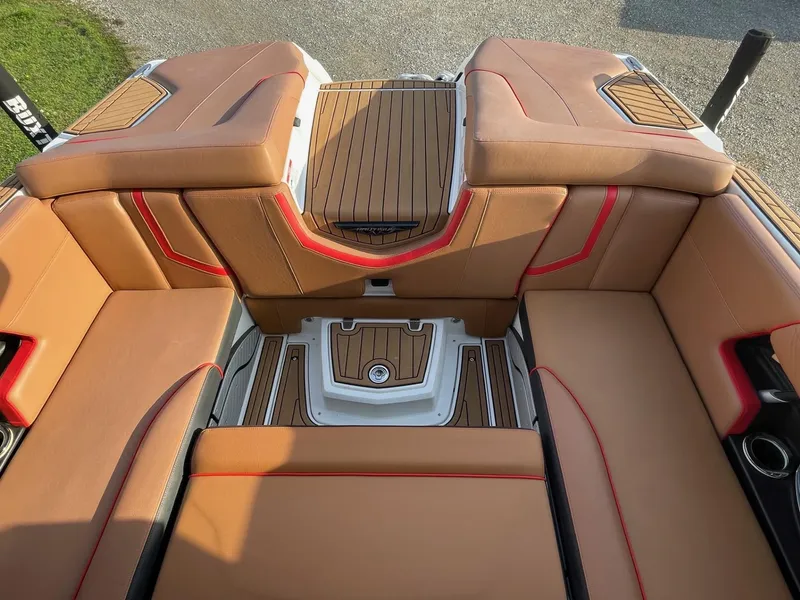 Slide: The Image of 2019 Nautique Super Air Nautique G25 interior with tan and red upholstery, teak flooring. - 7