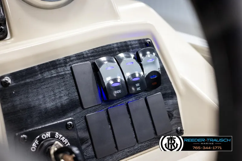 Slide: The Image of Close-up of 2025 Avalon VEN CRB boat control panel with switches and ignition. - 32