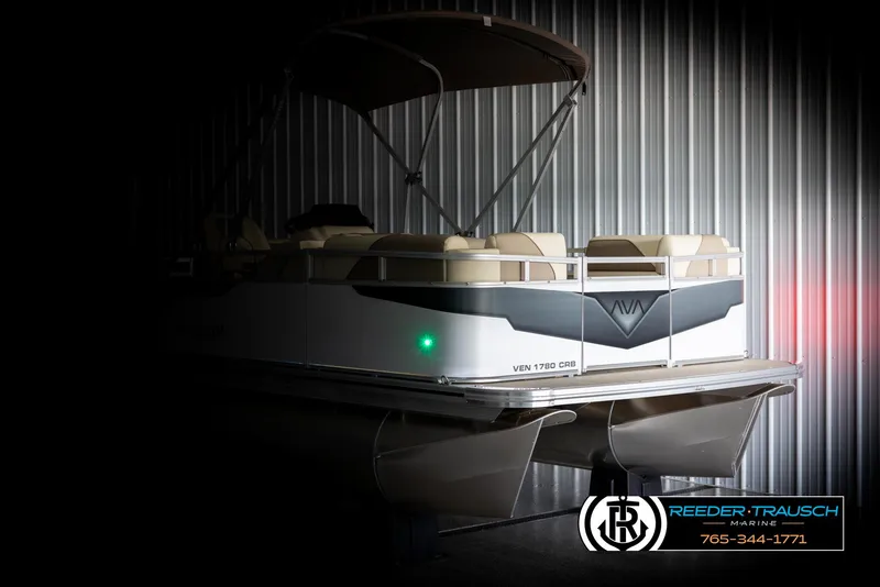 Slide: The Image of 2025 Avalon VEN CRB pontoon boat in a dimly lit showroom. - 4