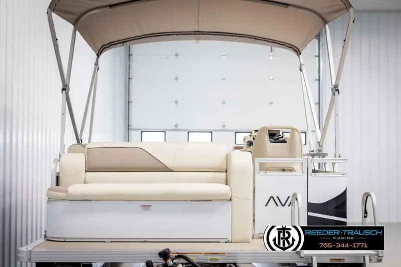 Slide: The Image of 2025 Avalon VEN CRB boat with beige seating and canopy in a showroom. - 7