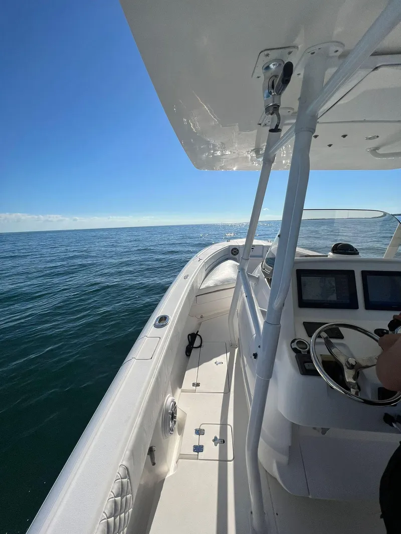 Slide: The Image of 2004 Intrepid 300 Center Console boat cruising on open sea under clear blue sky. - 3