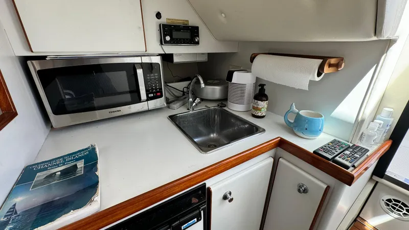Slide: The Image of 2003 Tiara Yachts 2900 Coronet kitchenette with microwave, sink, and countertop essentials. - 3