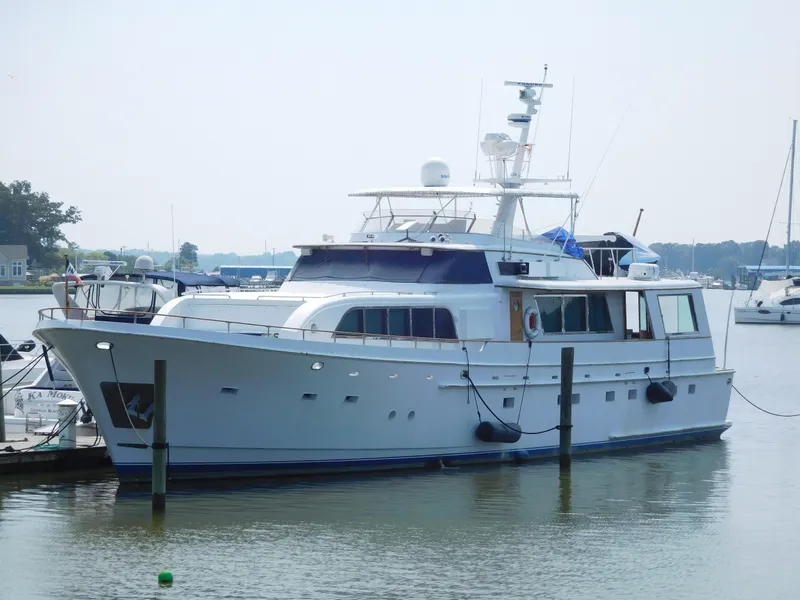 Slide: The Image of 1983 Cheoy Lee 90 cockpit motor yacht docked in a serene marina. - 1