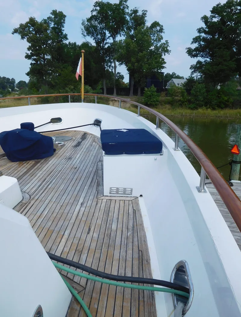 Slide: The Image of 1983 Cheoy Lee 90 cockpit motor yacht deck with wooden flooring and covered seating. - 12