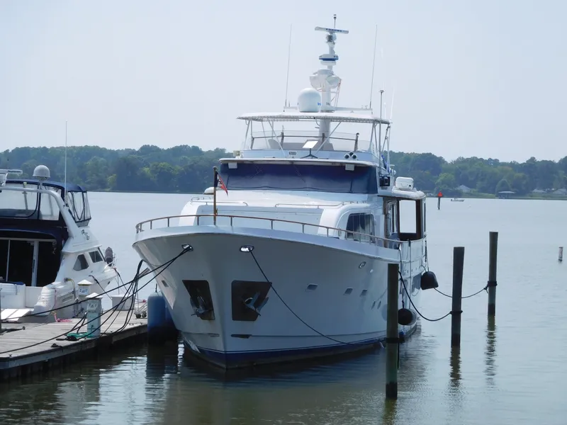 Slide: The Image of 1983 Cheoy Lee 90 cockpit motor yacht docked on calm water. - 2