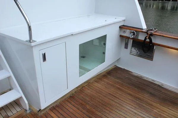 Slide: The Image of 1983 Cheoy Lee 90 cockpit motor yacht deck with wooden flooring and storage compartment. - 33