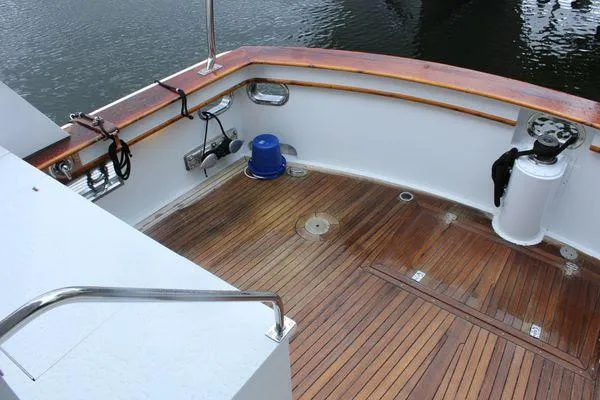 Slide: The Image of 1983 Cheoy Lee 90 cockpit motor yacht with teak deck and railing, docked on calm water. - 38