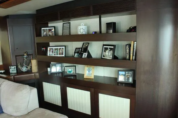 Slide: The Image of Interior of 1983 Cheoy Lee 90 yacht with wooden shelves and framed photos. - 45