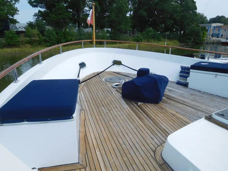 Slide: The Image of 1983 Cheoy Lee 90 cockpit motor yacht deck with seating and wooden flooring. - 6