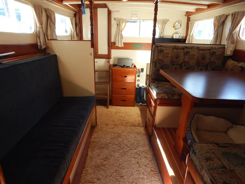 Slide: The Image of Interior of 1963 Grand Banks 35 Chantyman boat, featuring cozy seating and wooden furnishings. - 2