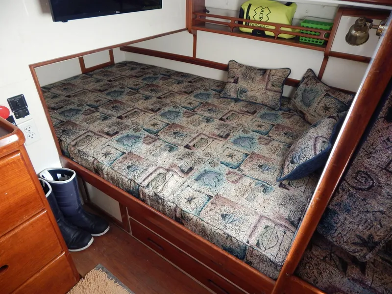 Slide: The Image of Cozy cabin bed in 1963 Grand Banks 35 Chantyman boat with patterned bedding and pillows. - 8