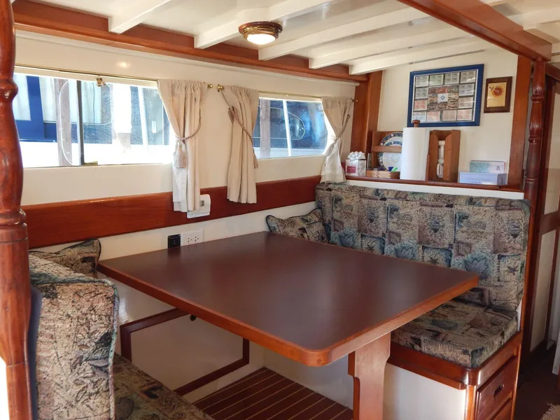 Slide: The Image of Interior of 1963 Grand Banks 35 Chantyman with wooden dining area and patterned seating. - 4