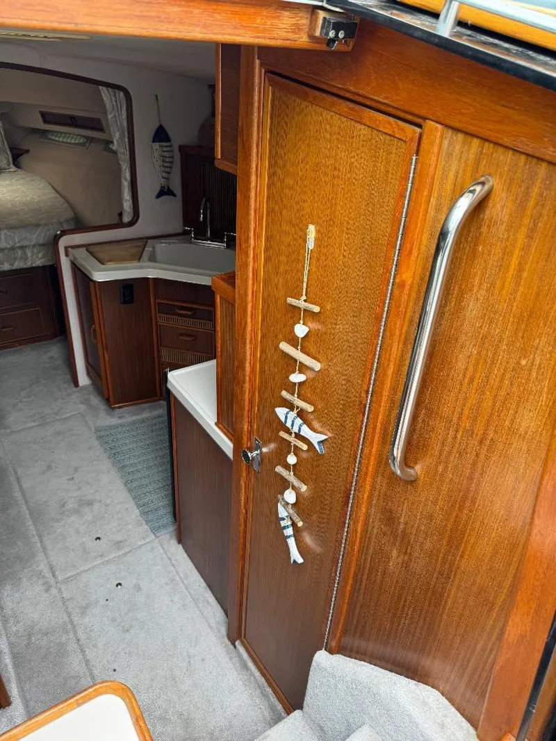 Slide: The Image of 1987 Sea Ray 340 Express Cruiser interior with wood finish and cozy cabin space. - 12