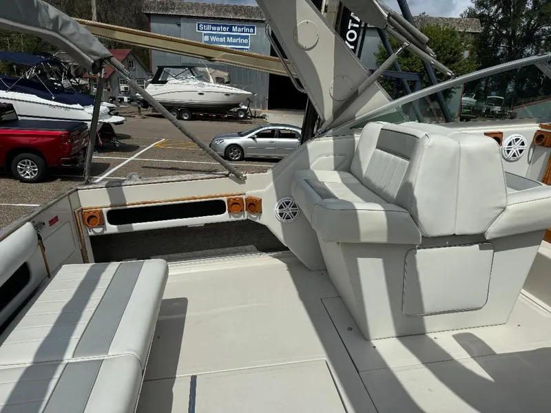 Slide: The Image of 1987 Sea Ray 340 Express Cruiser interior with white seating at a marina. - 18