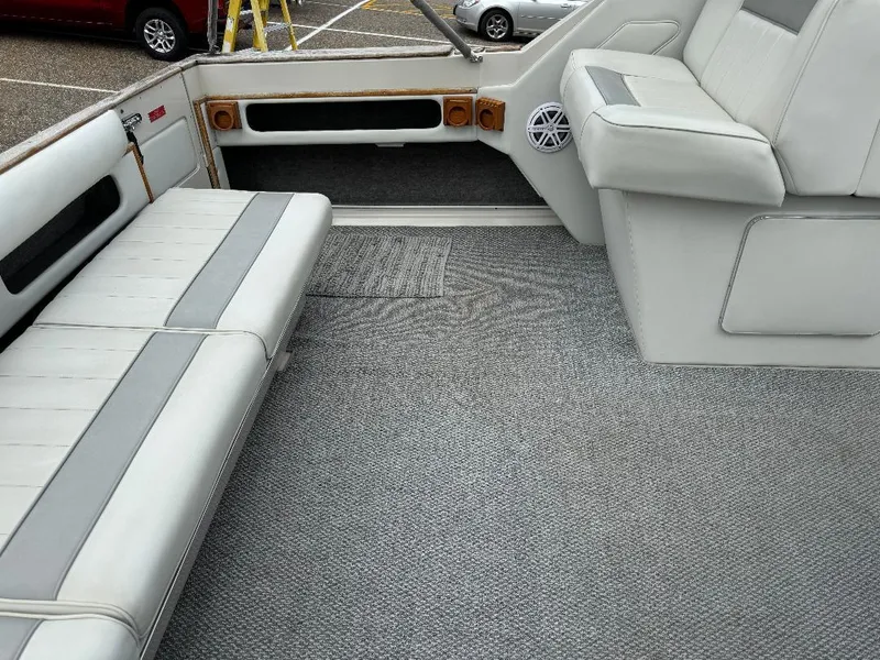 Slide: The Image of 1987 Sea Ray 340 Express Cruiser interior with gray seating and carpeted flooring. - 19