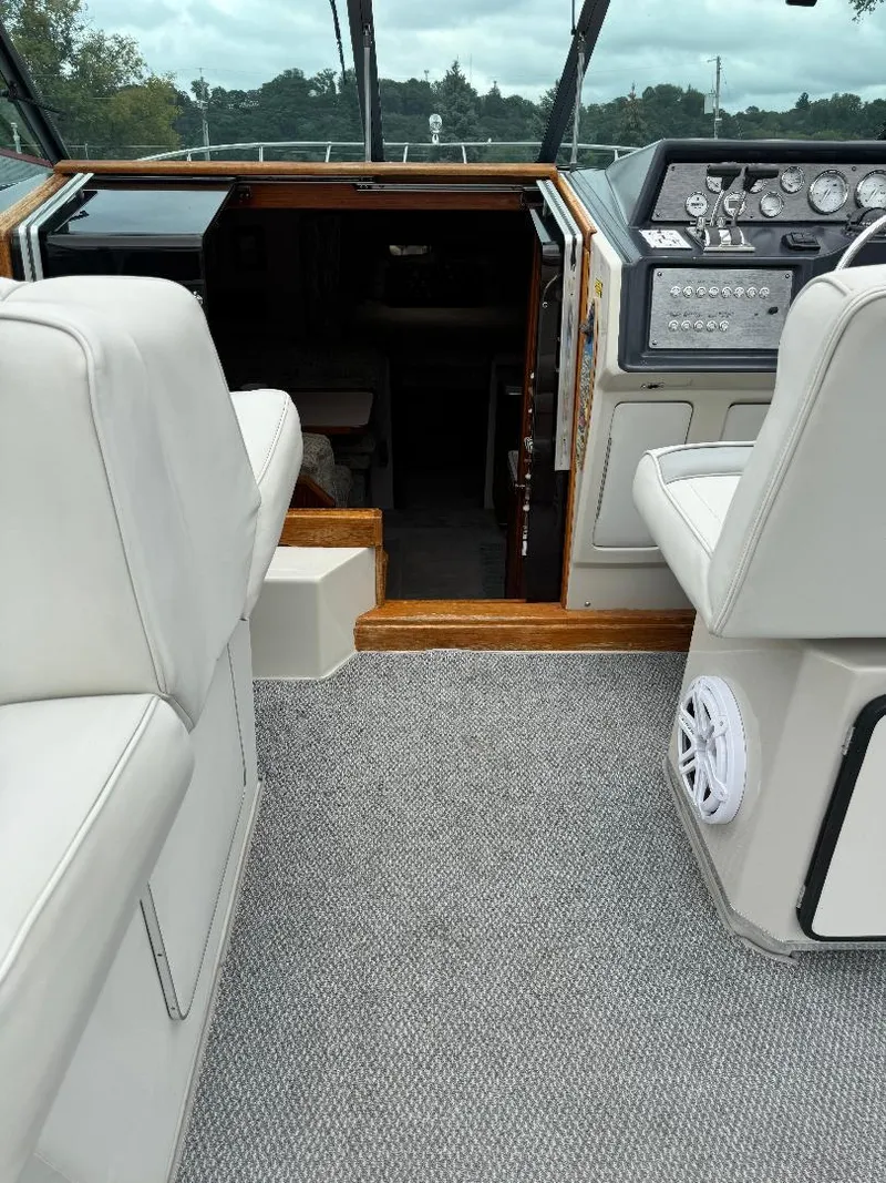 Slide: The Image of 1987 Sea Ray 340 Express Cruiser interior with helm, seating, and cabin entrance. - 22