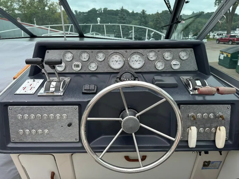 Slide: The Image of 1987 Sea Ray 340 Express Cruiser dashboard with steering wheel and control panel. - 26