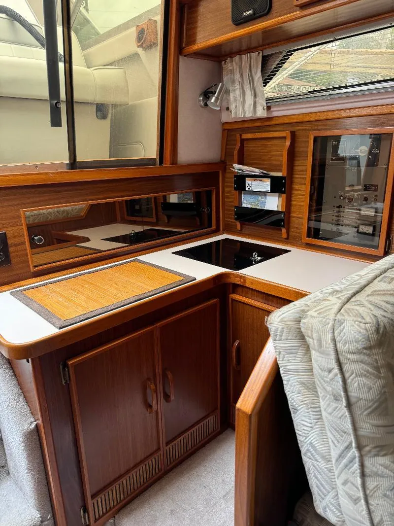 Slide: The Image of 1987 Sea Ray 340 Express Cruiser interior with wood cabinetry and compact kitchen area. - 5
