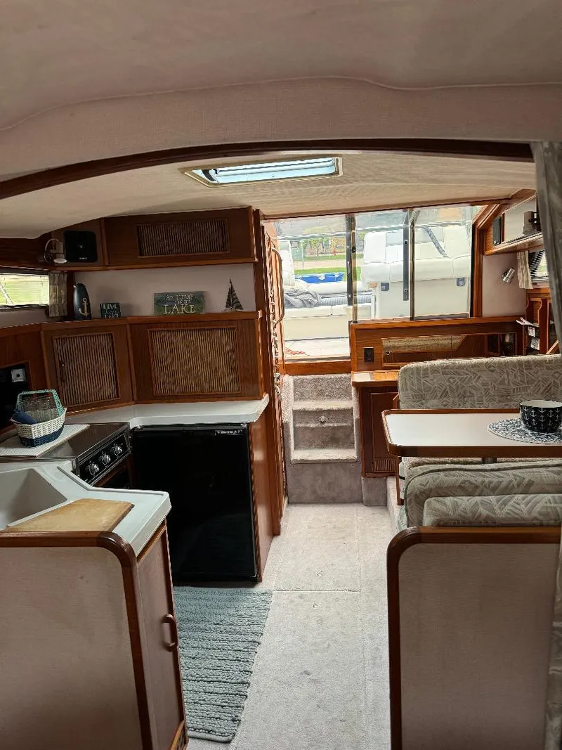 Slide: The Image of Interior of 1987 Sea Ray 340 Express Cruiser with kitchen and dining area. - 8