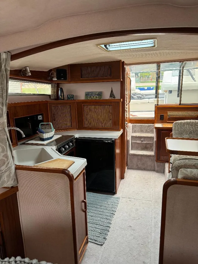 Slide: The Image of Interior of 1987 Sea Ray 340 Express Cruiser with kitchen and dining area. - 9