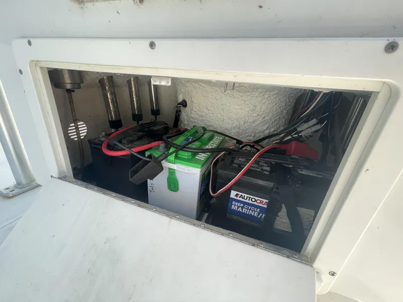 Slide: The Image of 2014 Sea Hunt Bay Boat BX 22 Pro battery compartment with marine batteries and wiring. - 11
