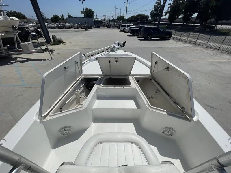 Slide: The Image of 2014 Sea Hunt Bay Boat BX 22 Pro with open storage compartments in a marina. - 17