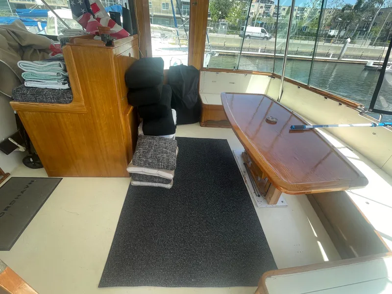 Slide: The Image of 1979 Hatteras 43 Motor Yacht interior with wooden table, seating, and marina view. - 12