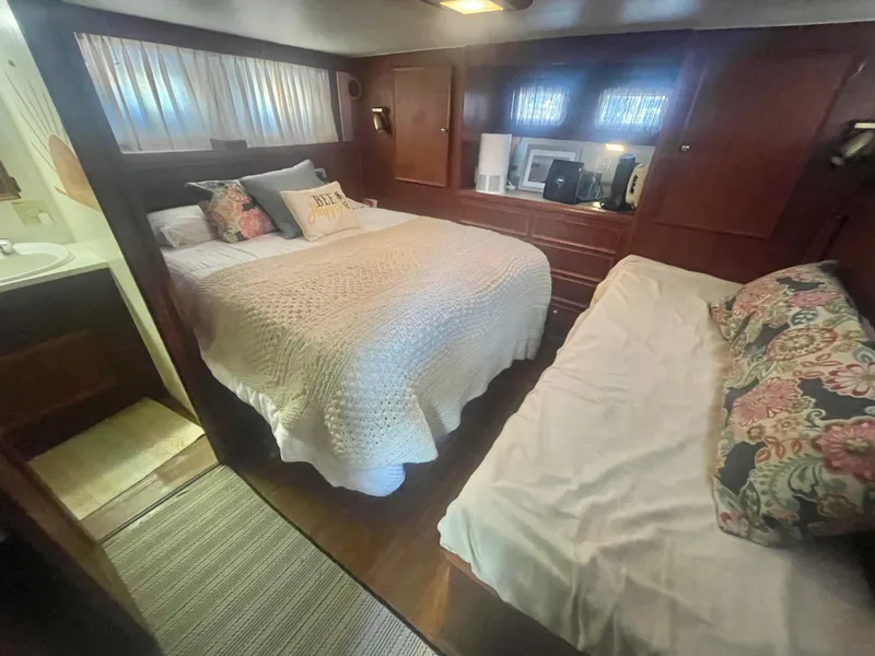 Slide: The Image of 1979 Hatteras 43 Motor Yacht bedroom with cozy bedding and wooden cabinetry. - 21