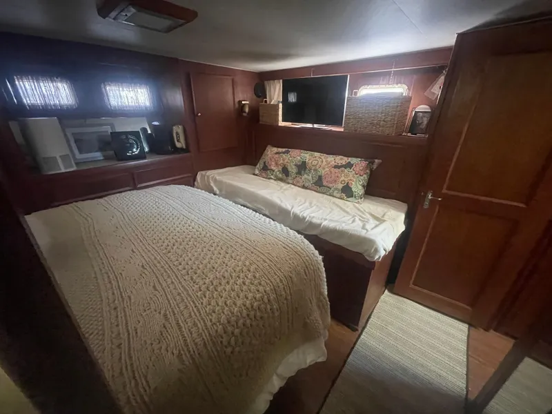 Slide: The Image of 1979 Hatteras 43 Motor Yacht interior with cozy bedroom, wooden paneling, and soft lighting. - 23