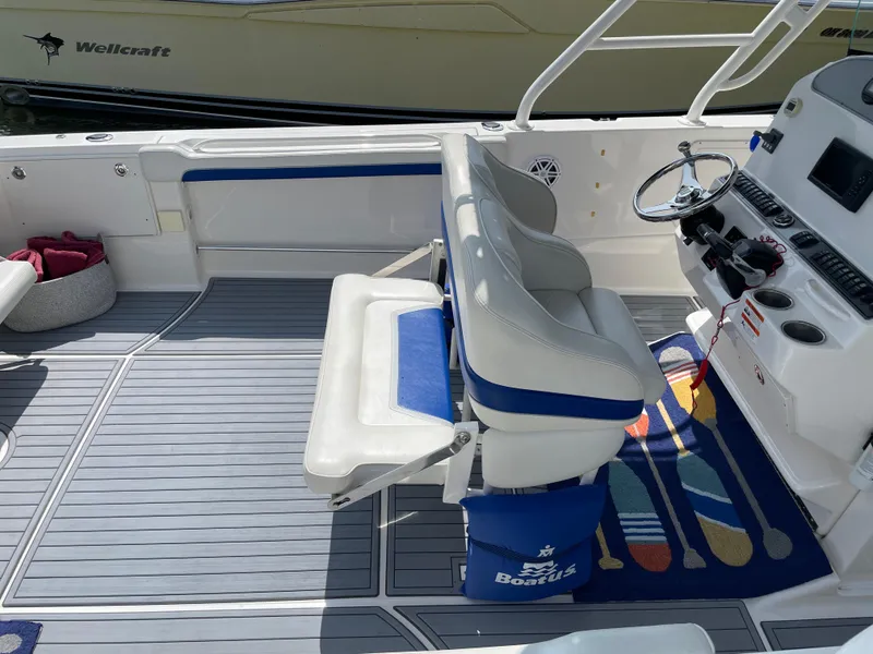 Slide: The Image of 2015 Wellcraft 35 Scarab boat interior with white and blue seating, steering wheel, and nautical decor. - 13