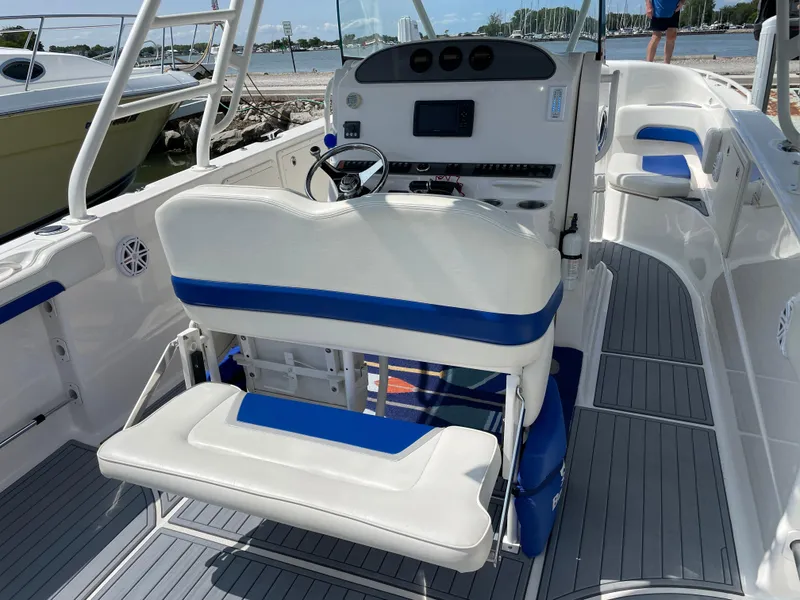 Slide: The Image of 2015 Wellcraft 35 Scarab boat interior with blue and white seating, steering console, and waterfront view. - 19